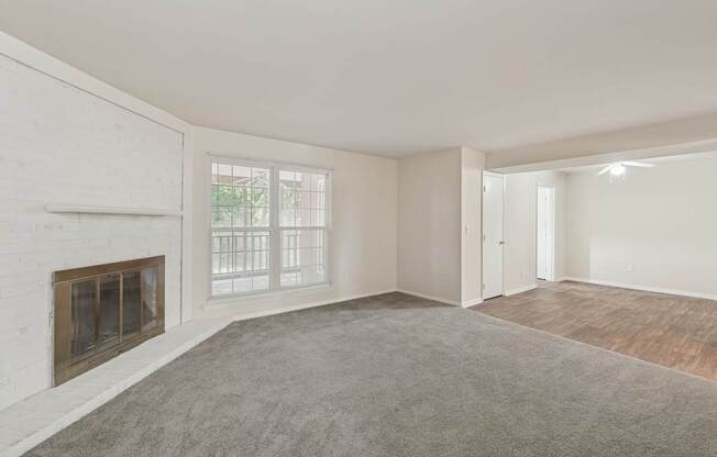 A room with a fireplace and a carpeted floor.