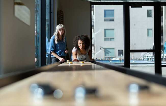 Two people playing a game of shuffleboard.