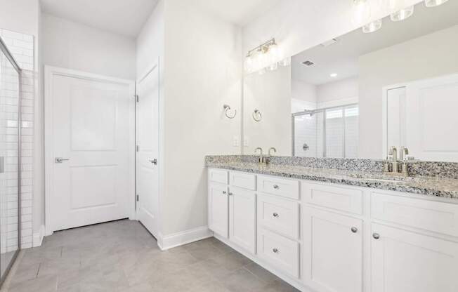 A bathroom with a white vanity and a white door.