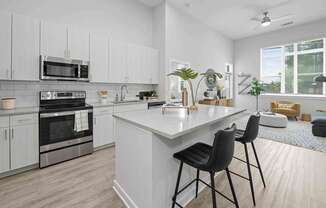 A modern kitchen with white cabinets and a large island.