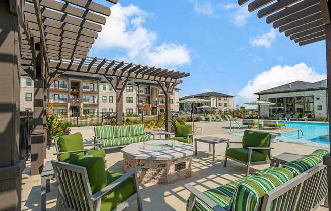 A sunny day at the poolside with green striped chairs and tables.