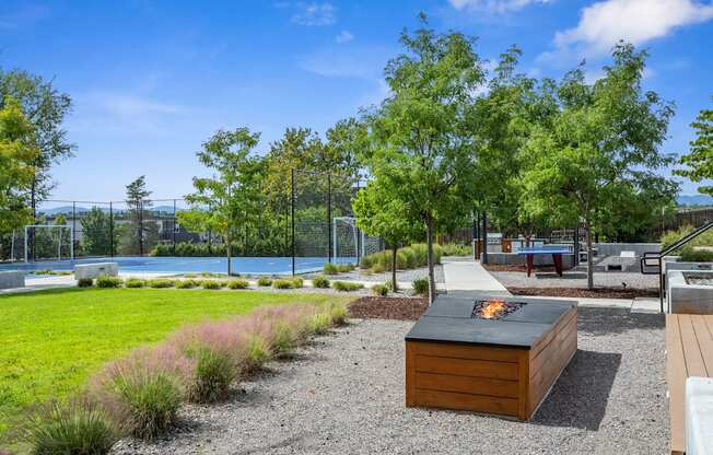 A backyard with a fire pit and a gravel area.