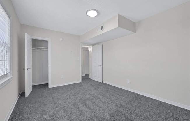 A spacious room with grey carpeting and white walls at Highland Ridge Apartments, Capitol Heights 20743