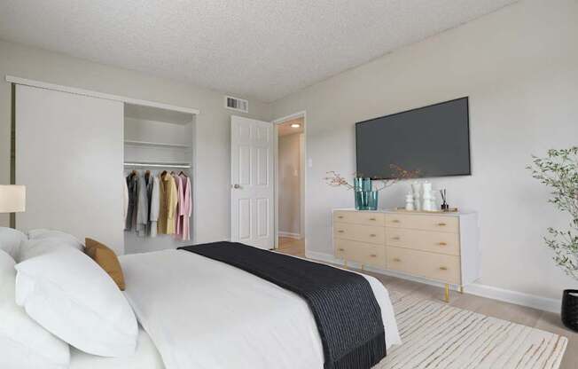 A bedroom with a bed covered in a yellow comforter.