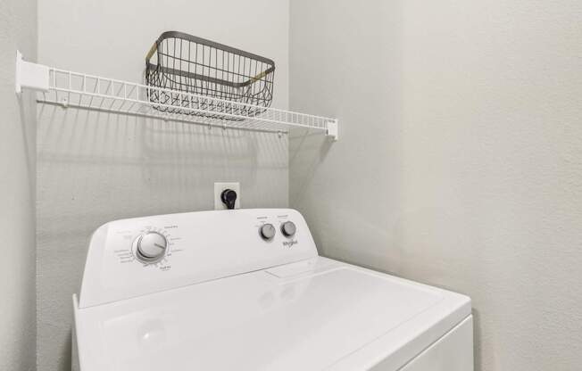 A white washing machine with a basket on top of it.