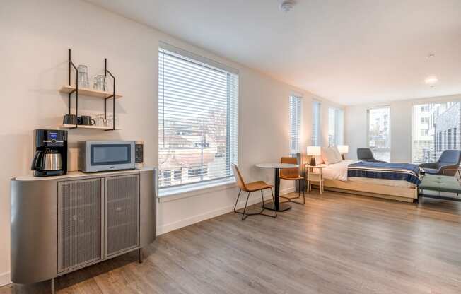 a bedroom with a bed and a tv in a room with a table and chairs at Marina Square, Bremerton, WA