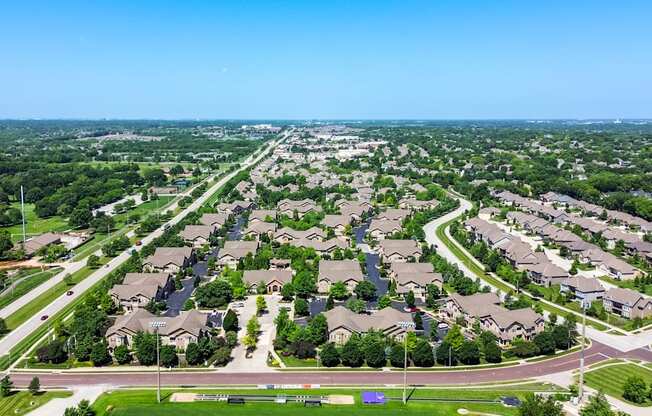 A suburban neighborhood with rows of houses and a clear blue sky.