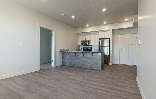 A living room with a kitchen in the background