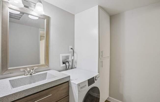 A white washing machine is in a small laundry room.