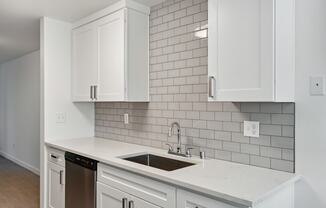 a kitchen with white cabinets and a sink