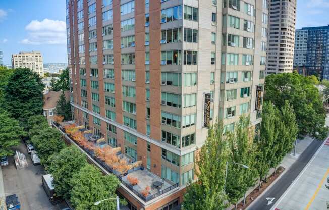 an aerial view of a tall building with trees in front of it