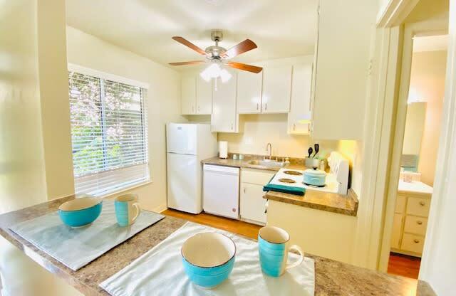 a kitchen with a table and a ceiling fan