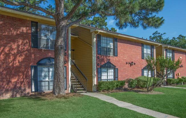 a house with a lawn in front of a brick building