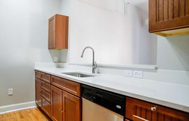 a kitchen with wooden cabinets and a white counter top and a sink