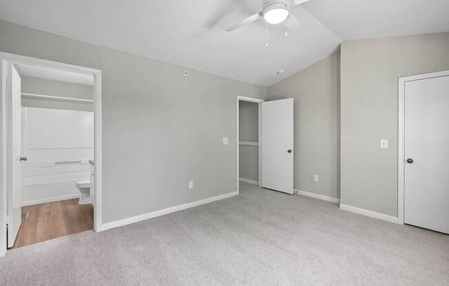 A spacious room with a ceiling fan and carpeted floor.