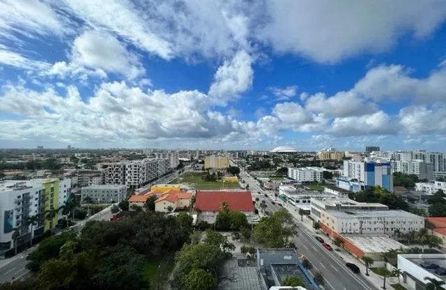 an aerial view of a city with a blue cloudy sky