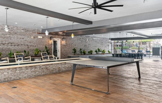 a ping pong table in a lobby with a brick wall