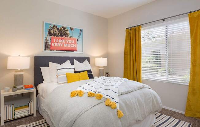 A bedroom with a bed, yellow curtains, and a poster that says "I like you very much".