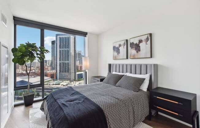 a bedroom with a bed and a large window and a view of the city at Cassidy on Canal, Chicago, IL