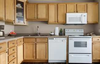 a kitchen with white appliances and wooden cabinets