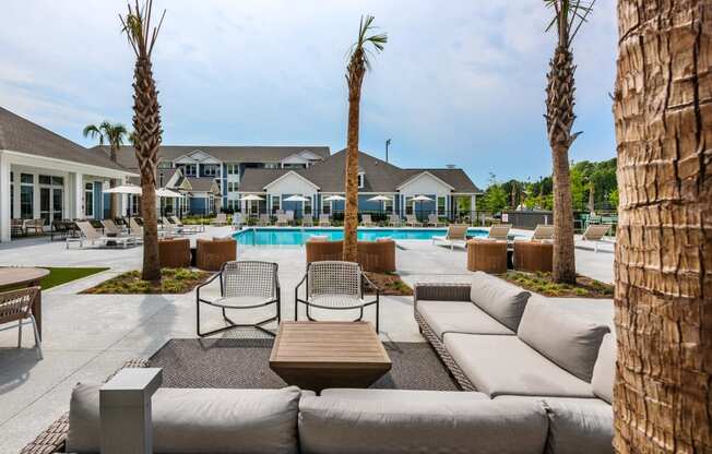 a pool with couches and chairs and palm trees