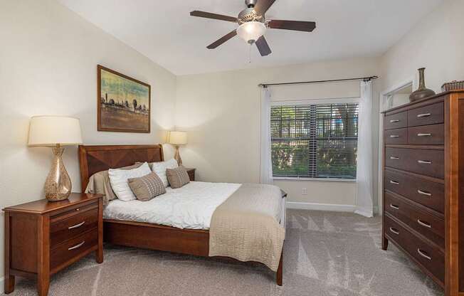 A bedroom with a bed, nightstand, and dresser.