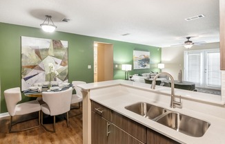 a kitchen with a sink and a dining room with a table and chairs at Crossgates Apartment Homes, Mississippi 39759