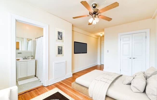 bedroom with bed, view of bathroom ceiling fan and hardwood floors at the foreland apartments in washinton dc