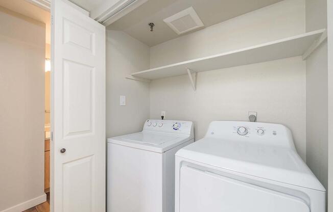 A small laundry room with a washer and dryer.