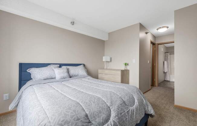 A bedroom with a large bed and a carpeted floor.