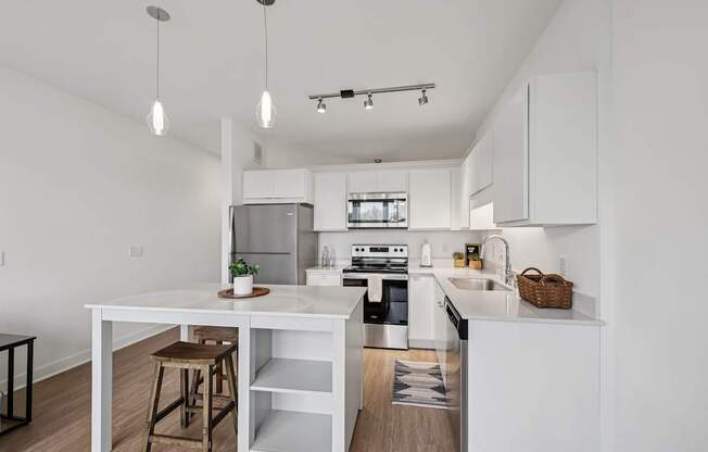 A white kitchen with a table and bar stools.