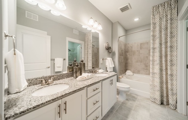 a bathroom with two sinks and a shower and a toilet