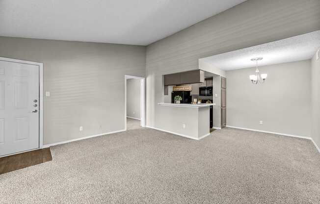 A spacious room with a carpeted floor and a white door.