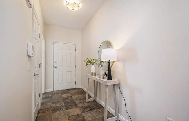 A lamp on a table in a room with a tiled floor.