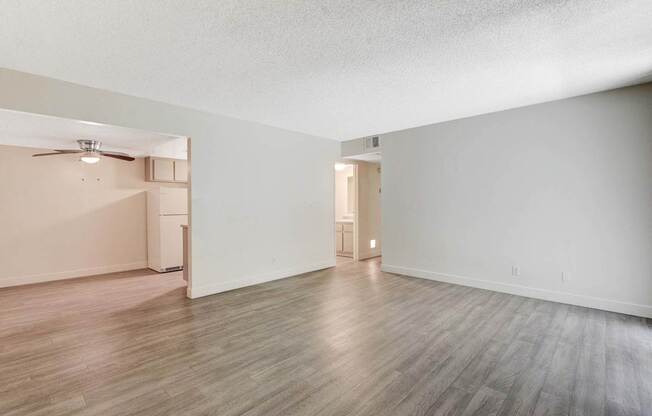 A room with a ceiling fan and a doorway leading to another room.