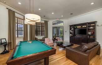 A room with a pool table and a couch.