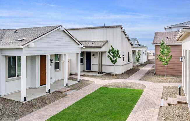 A row of houses with a green lawn in front.