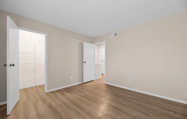 A room with wooden floors and white doors.