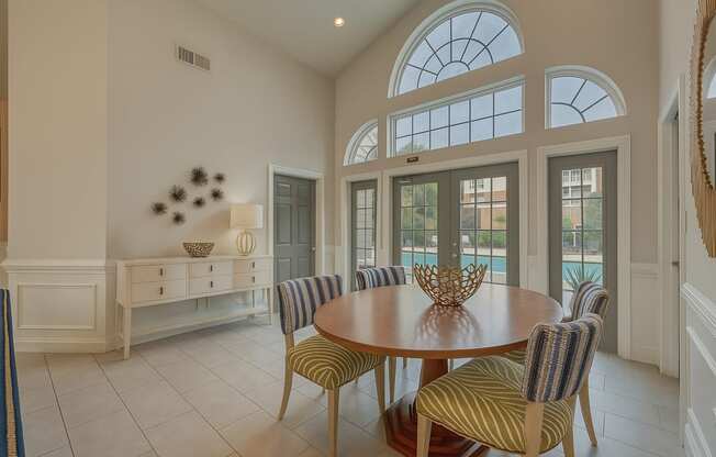 A dining room with a round table and striped chairs.
