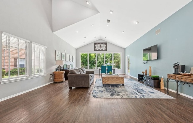 A spacious living room with a grey sofa and a wooden coffee table.