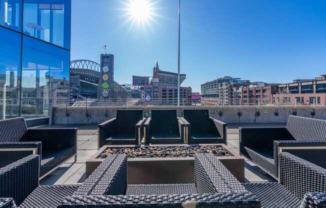 views of the city skyline from the roof of a building with lounge chairs