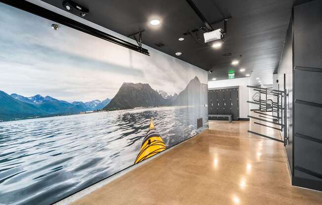 A wall mural of a kayak on a lake with mountains in the background.