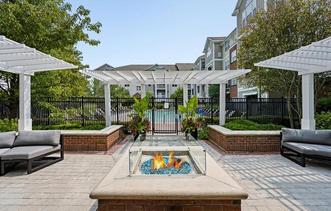 Fire pit courtyard with pergola-covered seating, gathering areas, and landscaped surroundings designed for conversation and comfortable evenings outdoors.