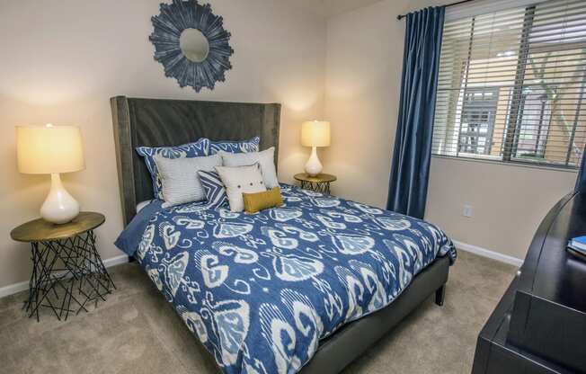 a bedroom with a bed with blue and white bedding and a window