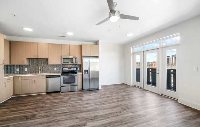 A kitchen with wooden floors and a ceiling fan.