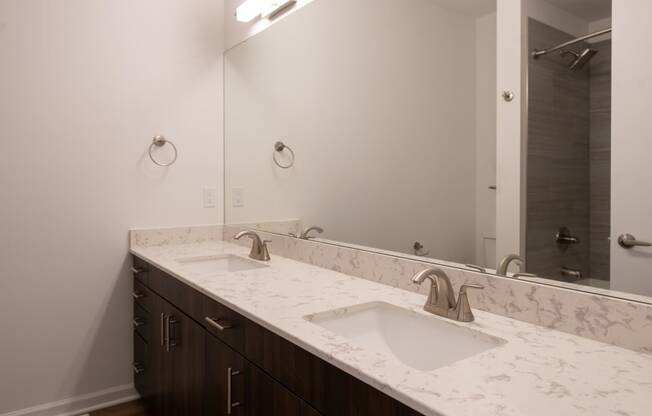 a bathroom with two sinks and a large mirror at The Clearing at ONE28, Olathe, KS