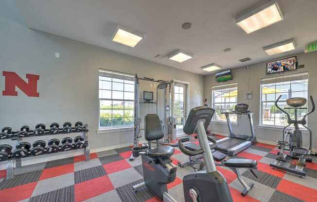 a gym with cardio equipment and weights at the enclave at woodbridge apartments in sugar land,