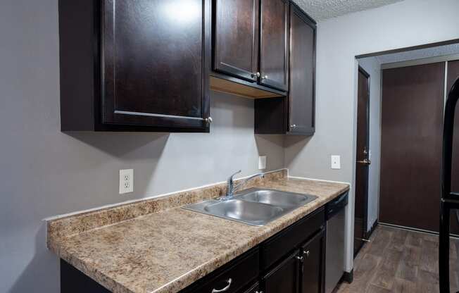 a kitchen with dark wood cabinets. Roseville, MN Rosedale Estates Apartments