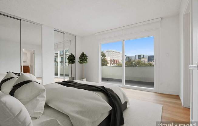 A bedroom with a bed, pillows, and a view of the city.