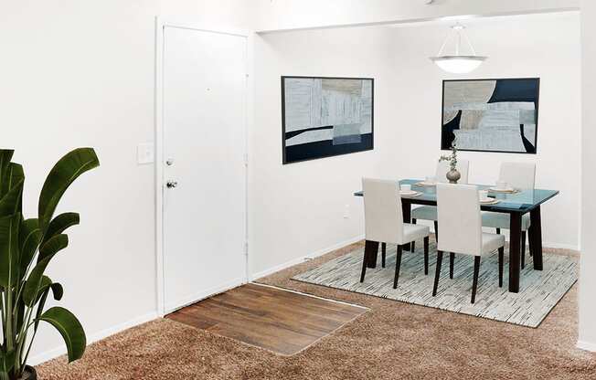 A dining room with a table and chairs.